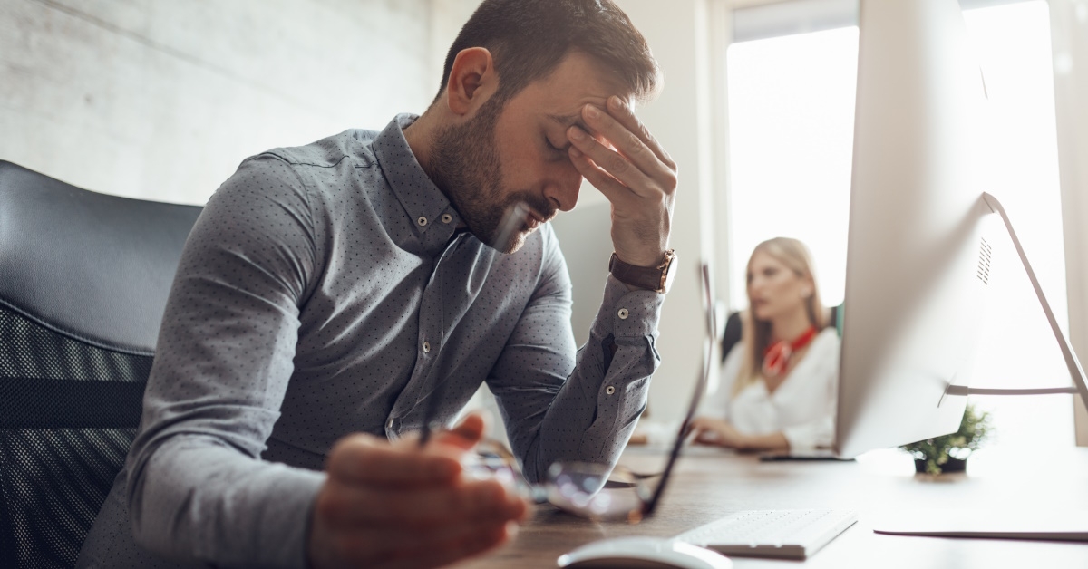 Businessman in office struggling with work