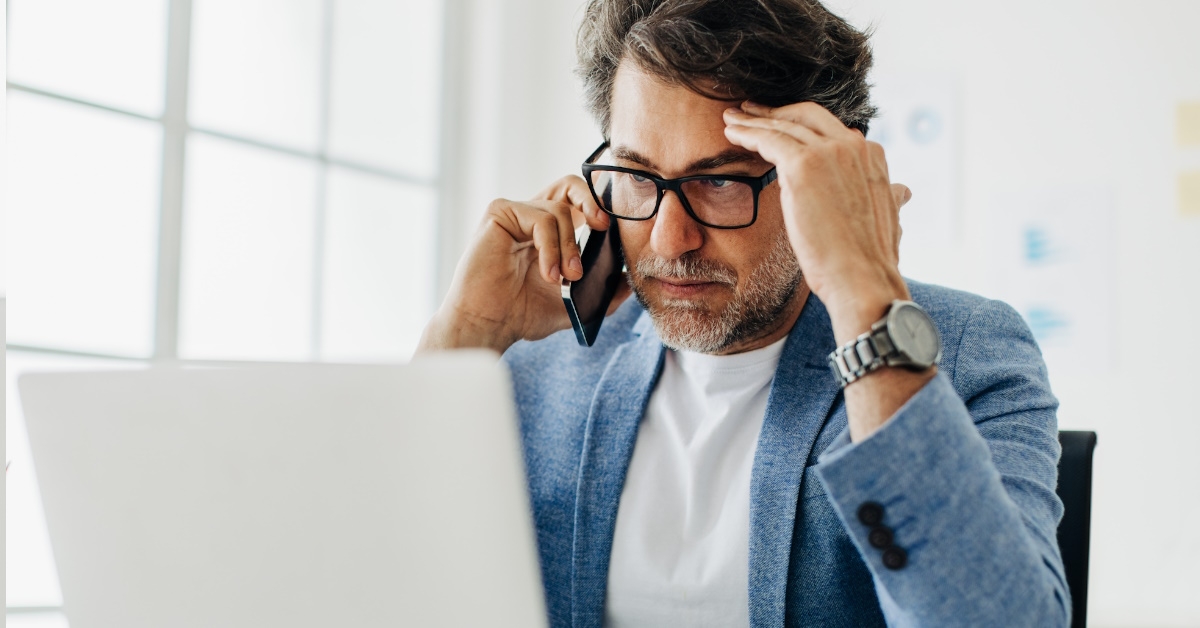 Stressed businessman having call at work