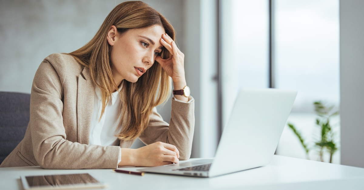 Stressed business woman using laptop