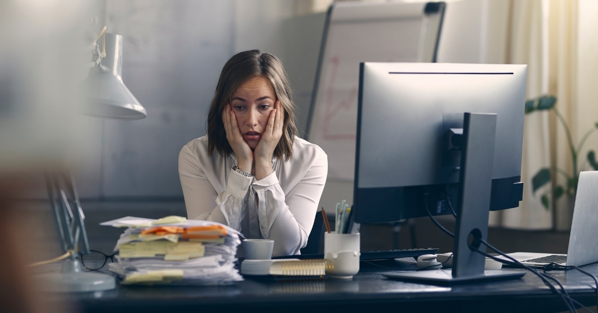 Young woman stressing at work desk
