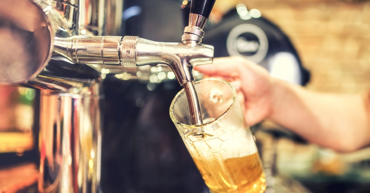 Barman hand at beer tap