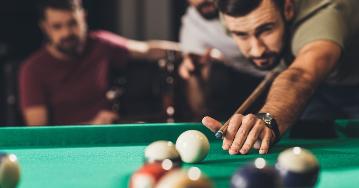 man playing in pool with friends