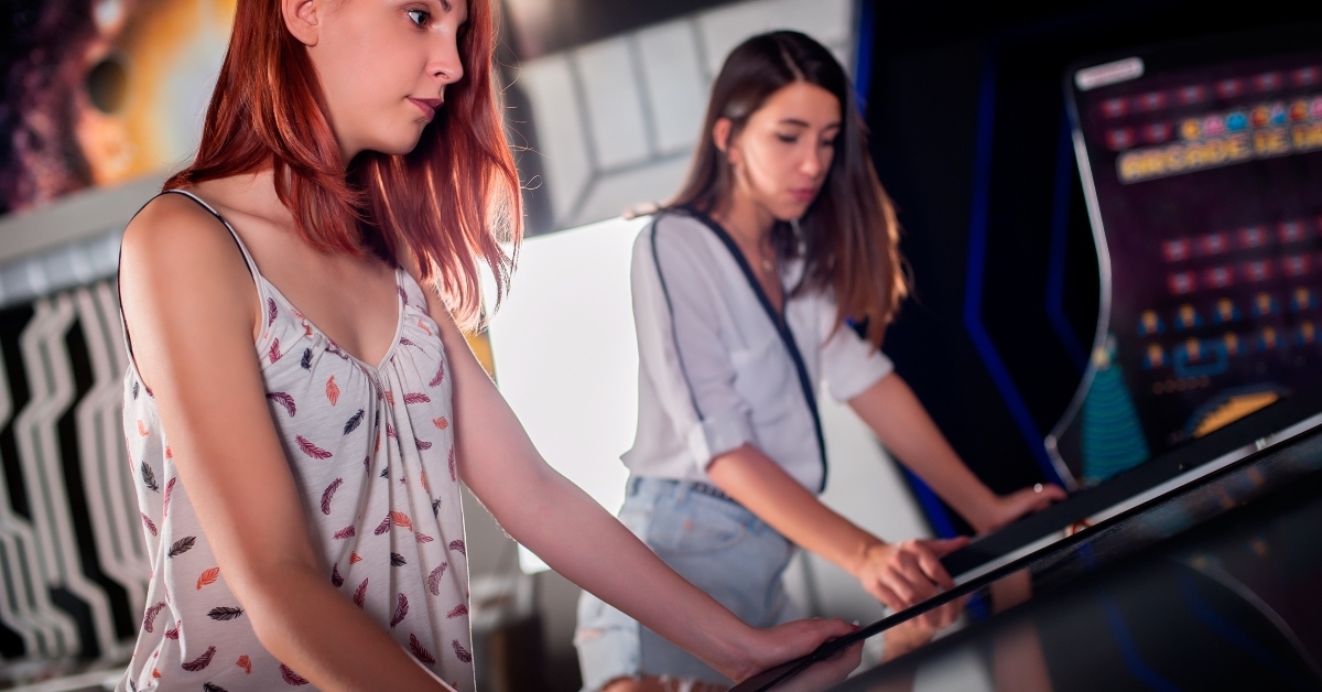 young woman playing pinball