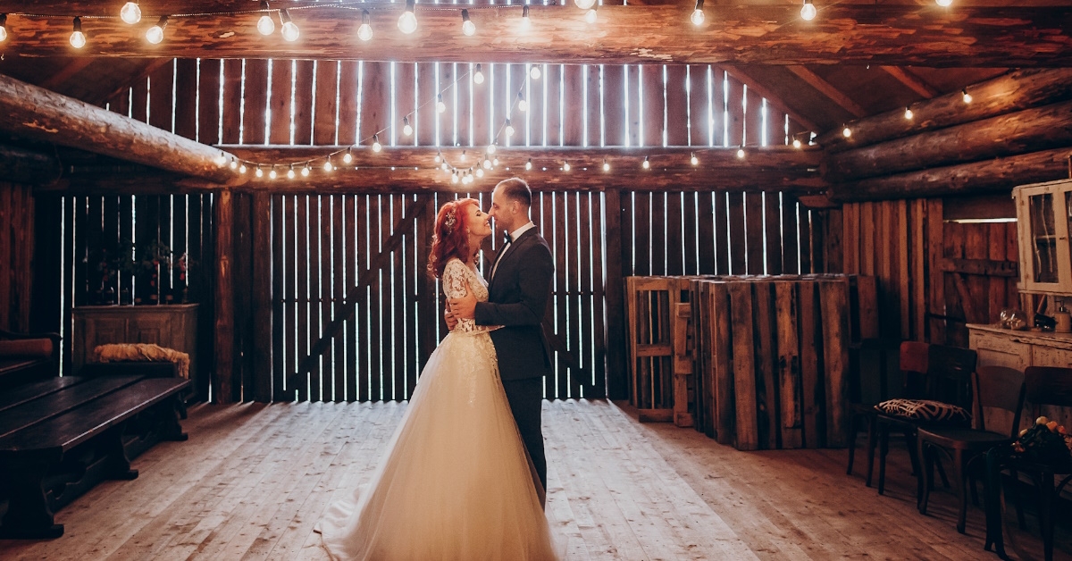 newlyweds couple dancing inside wooden barn