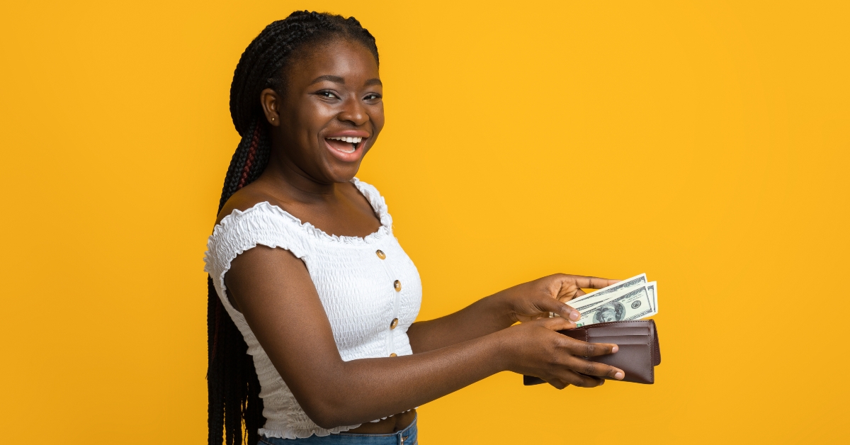 woman putting banknotes into wallet