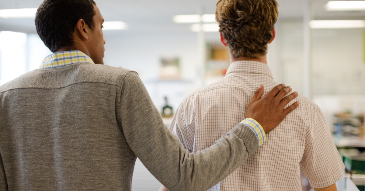 Businessman comforting colleague in office
