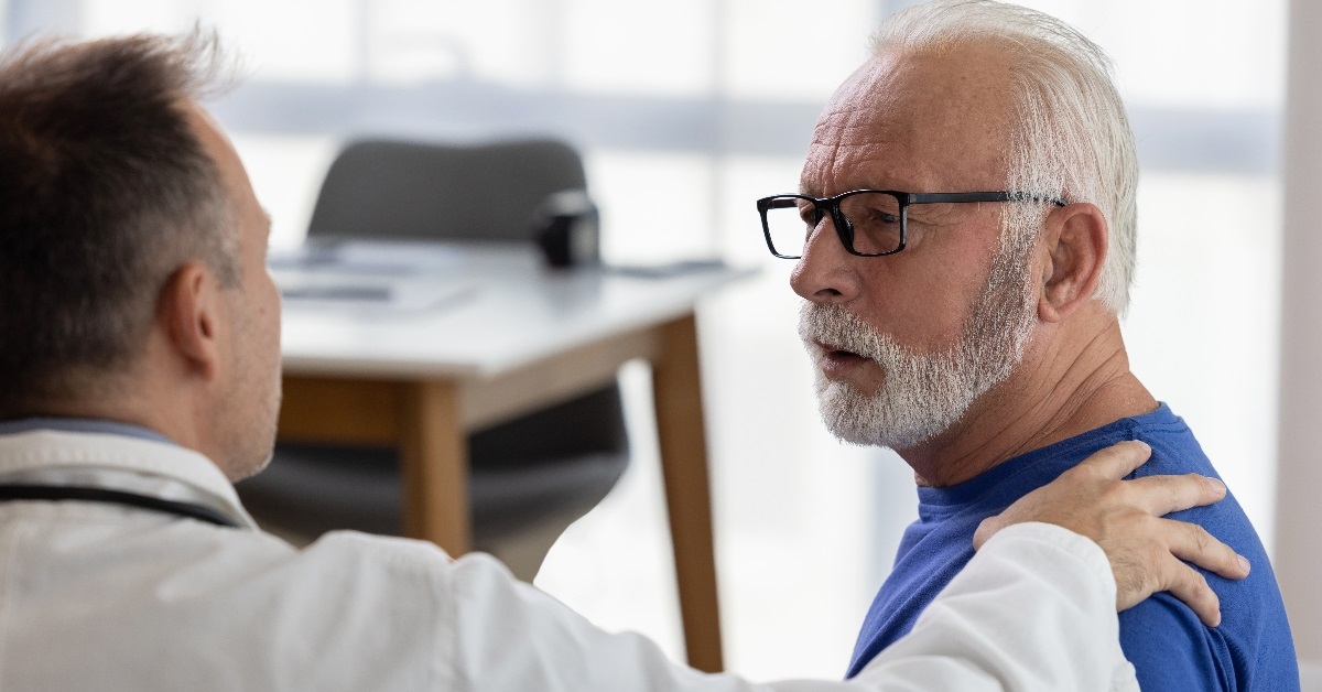 doctor talking to senior man at clinic