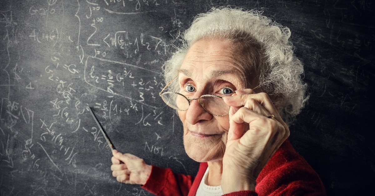 senior teacher pointing at blackboard