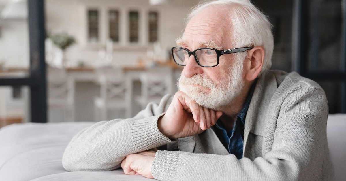 depressed senior man resting on couch