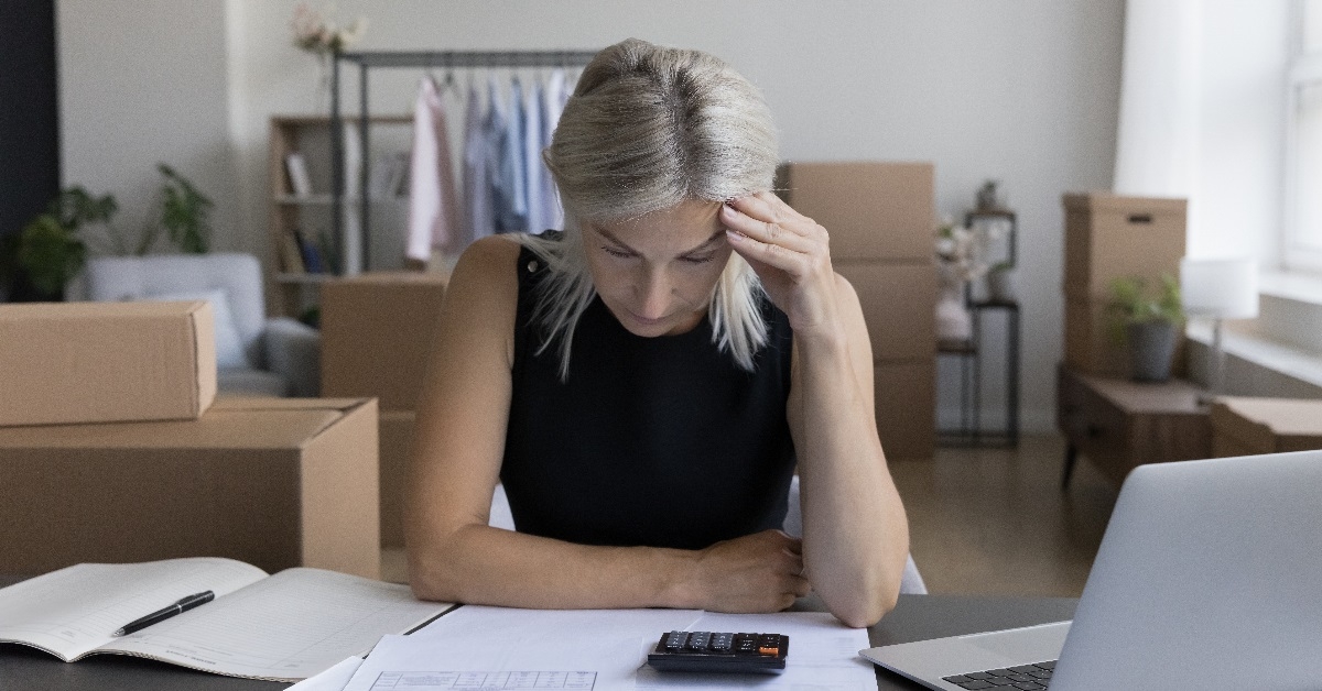 senior woman stressing while reviewing invoices