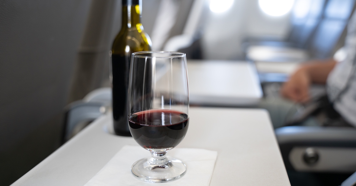 A glass of wine on a plane tray table