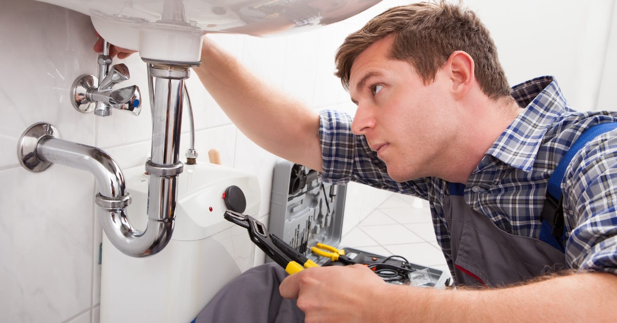 plumber fixing sink in bathroom