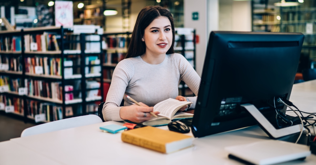 Woman making notes in library