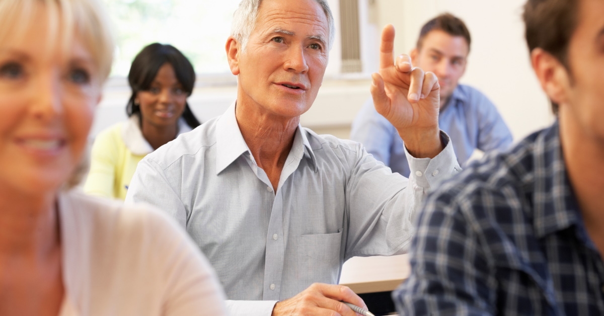 Senior student raising hand in class