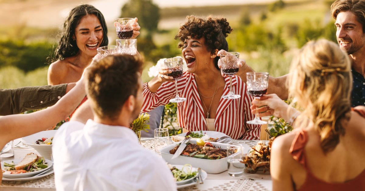 Cheerful friends at wine party outdoors
