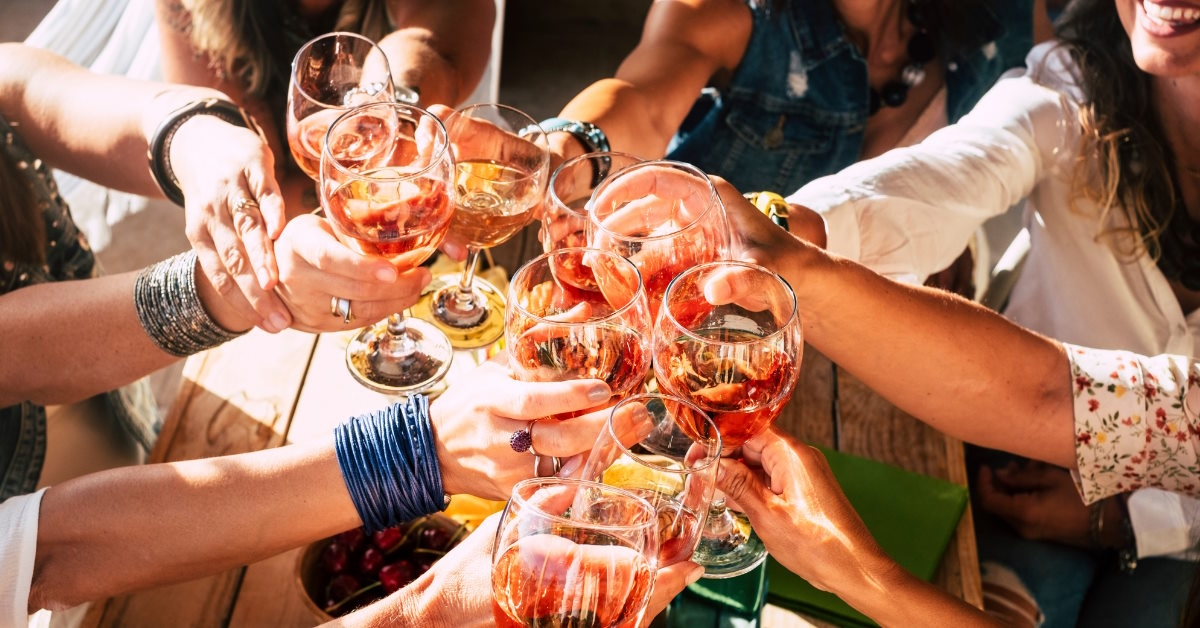 Woman celebrating by toasting wine glasses