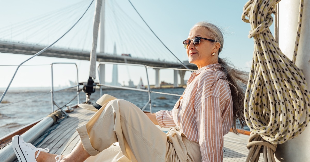 Stylish mature woman sitting on a yacht bow.