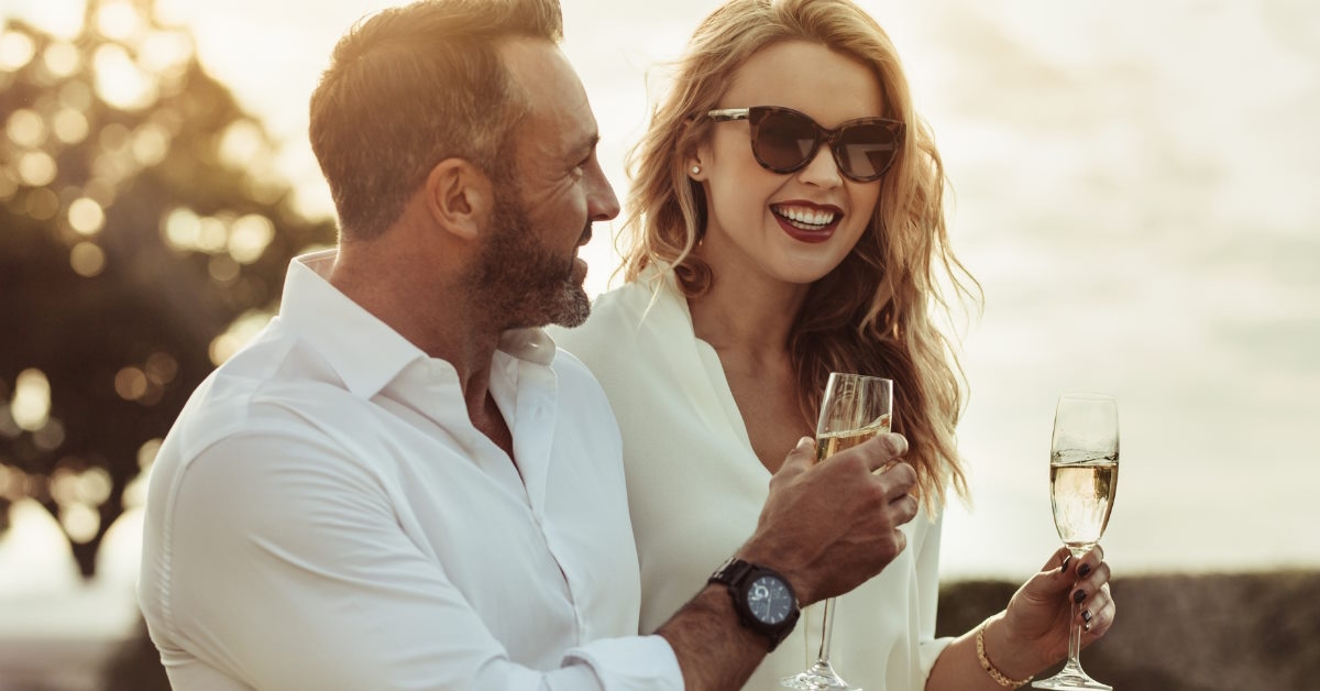Happy couple having white wine outdoors