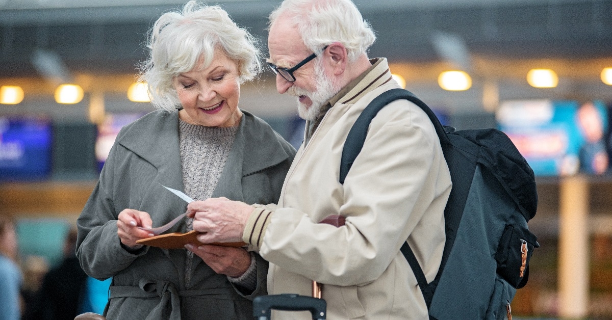 Couple checking travel documents at airport. 