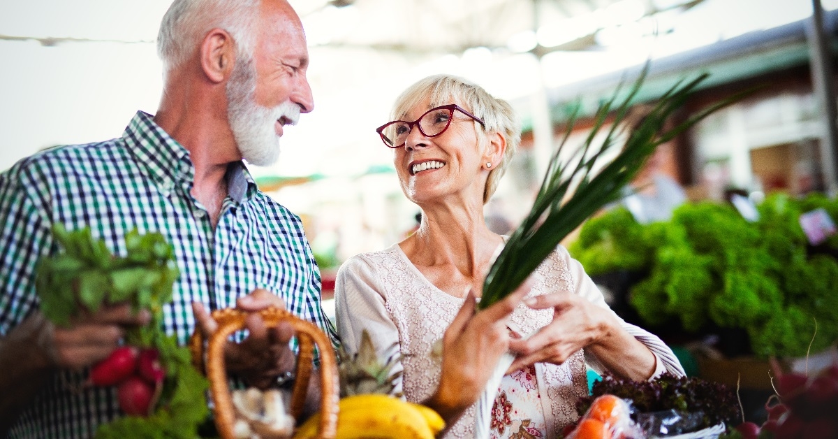 Gorgeous senior couple buying fresh vegetables.