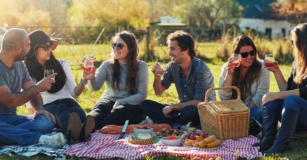 friends enjoying picnic together outdoors