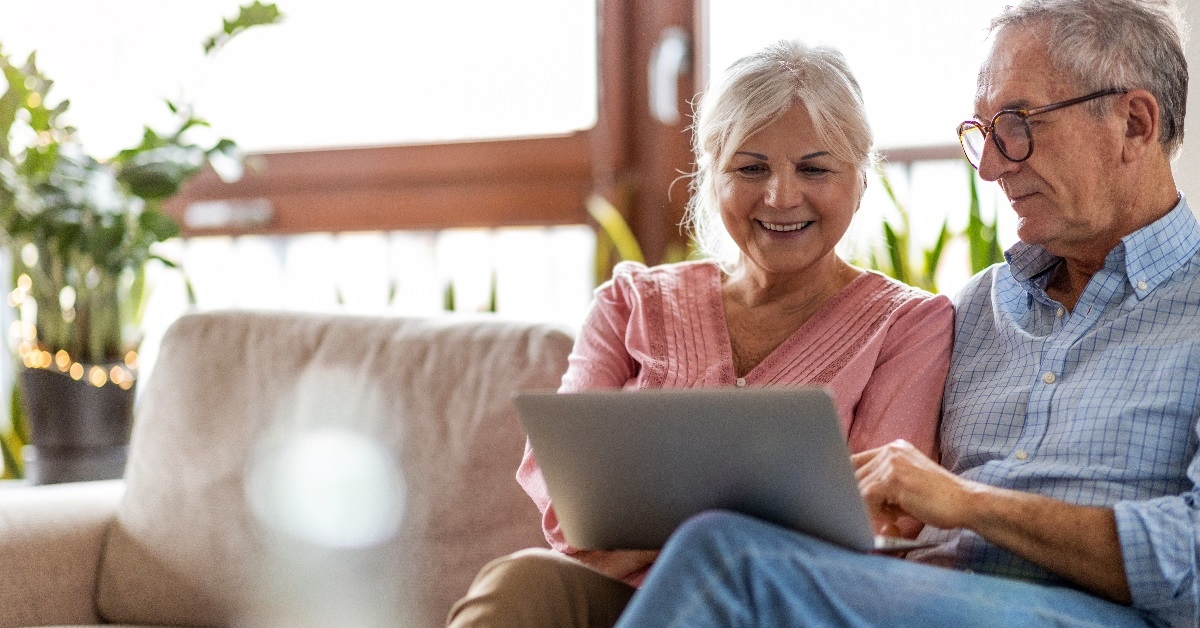 Couple using a laptop while relaxing at home