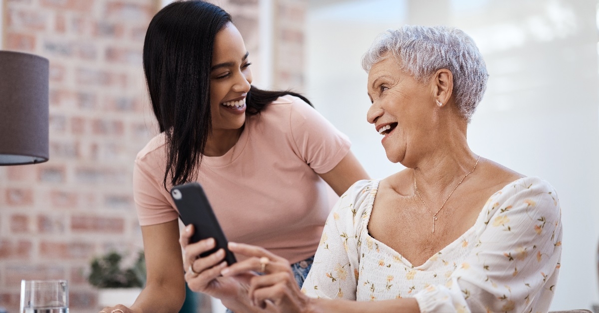 Elderly mother using smartphone with daughter