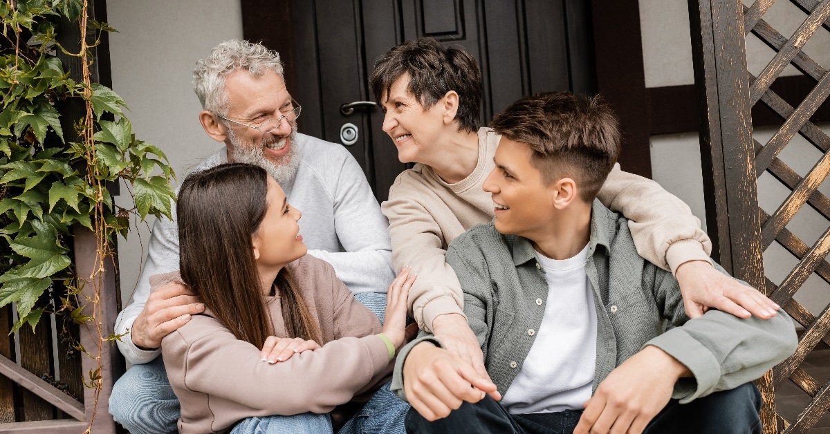 Children and parents sitting on porch of house
