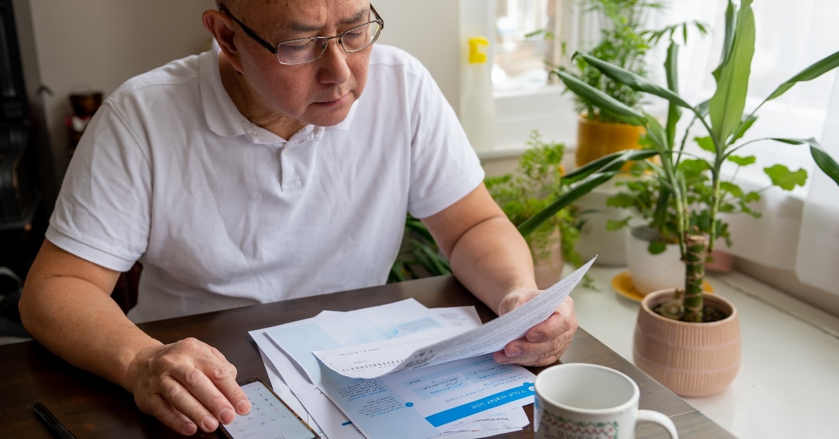 Senior man calculating total expenses