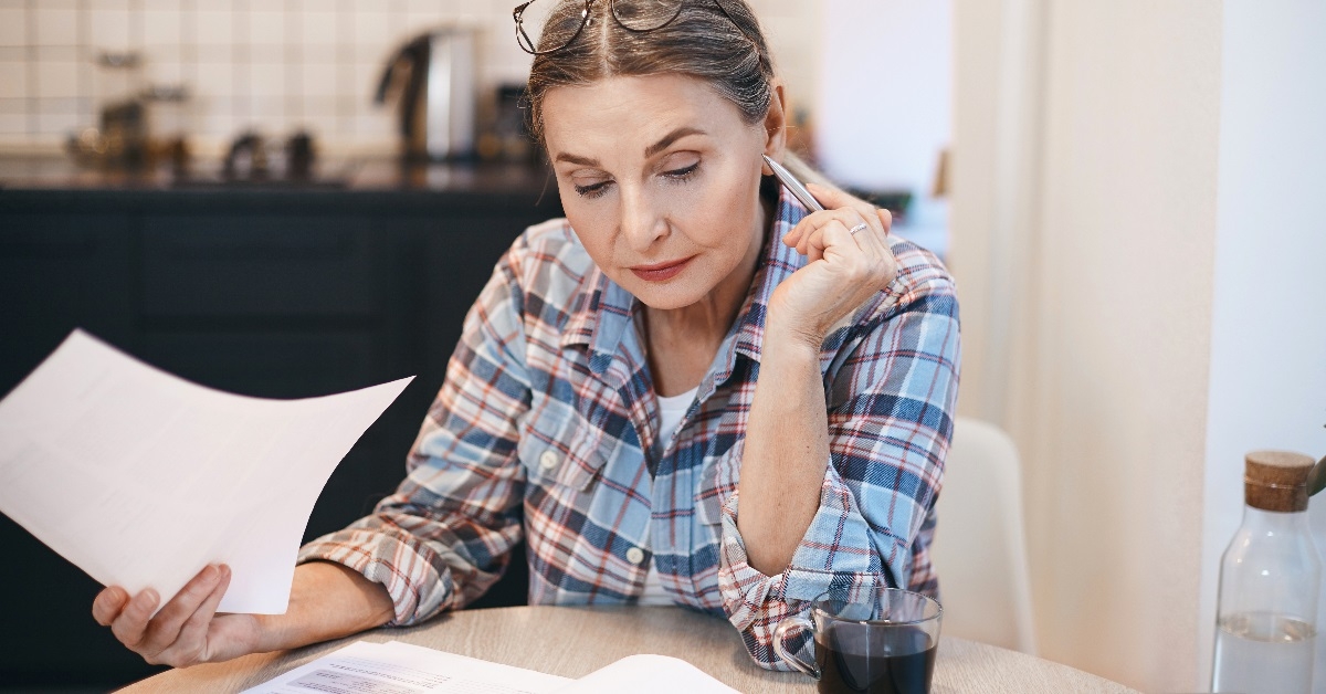 Woman engrossed in paper-related tasks.