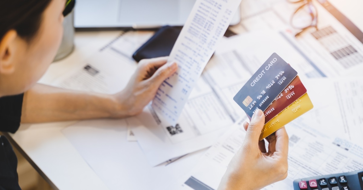 Woman reviewing bills while holding cards
