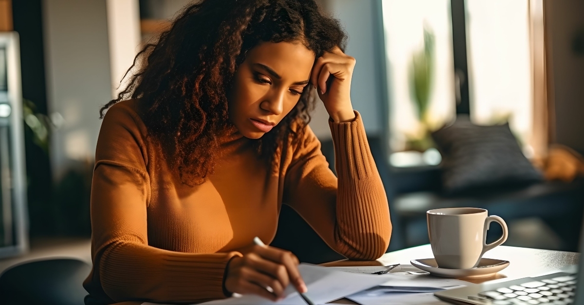 stressed young woman reviewing her bills