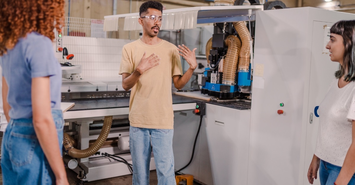 male technician explaining machinery to interns