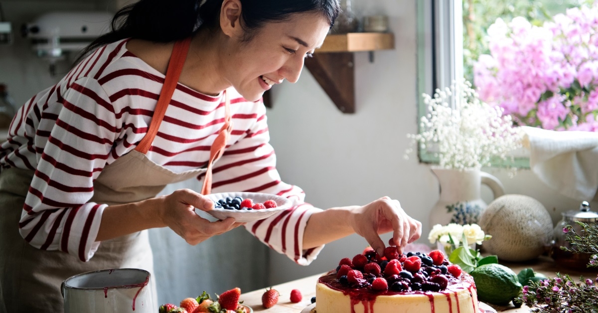 asian baker decorating berries cheesecake