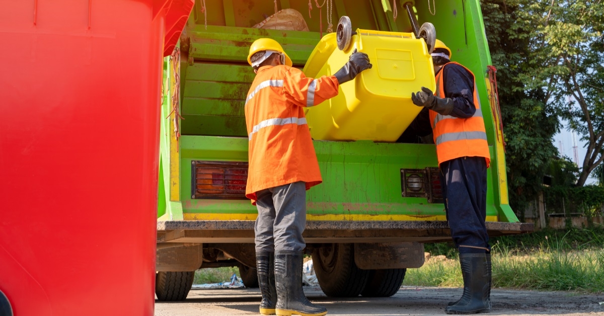 garbage men unloading trash into truck