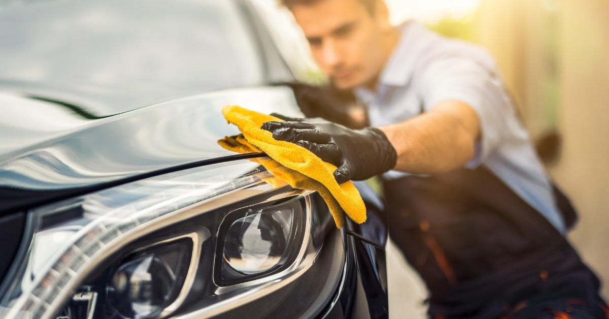 male auto detailer polishing car