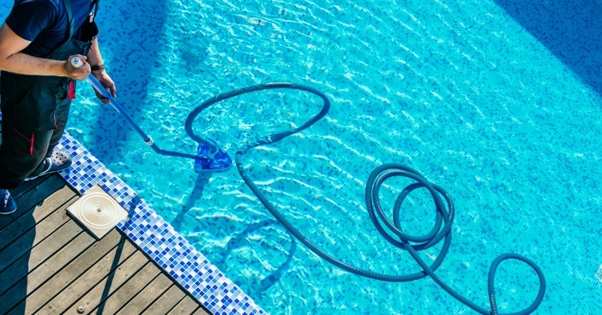 man using equipment to clean pool