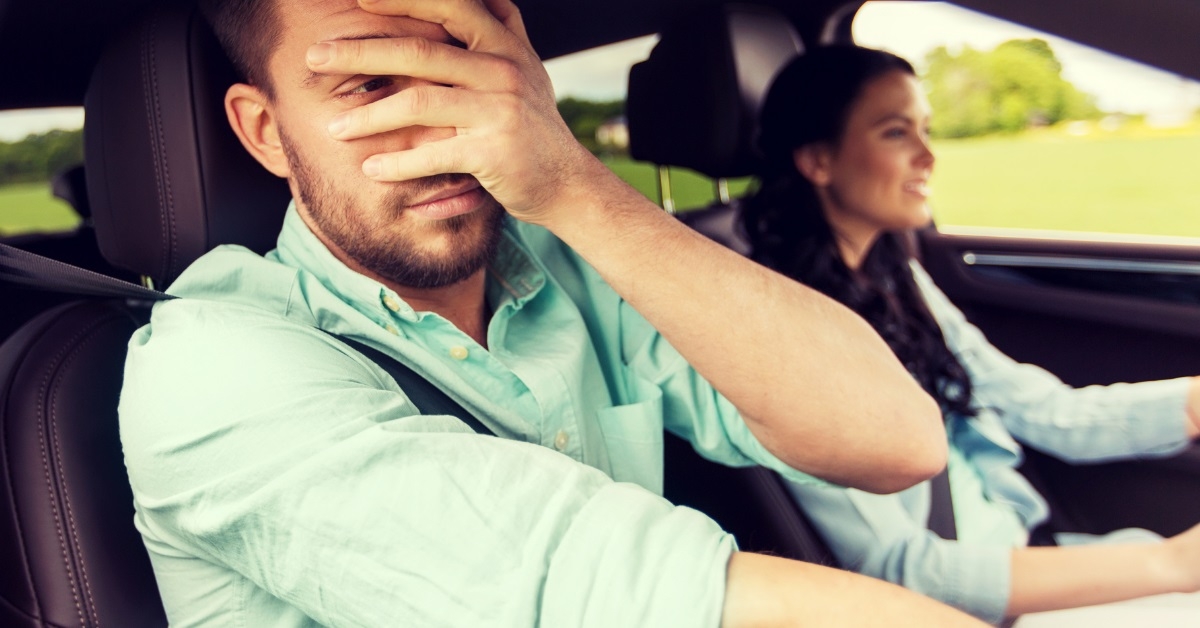 frightened man driving car with wife