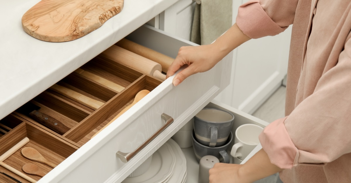 Woman opening drawers of kitchen