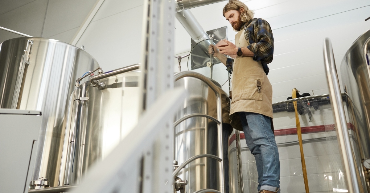 bearded brewmaster controlling production