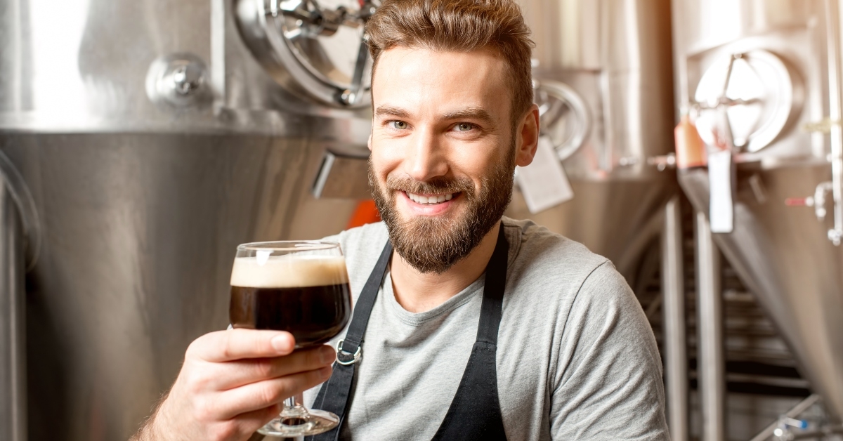 brewer in uniform tasting beer