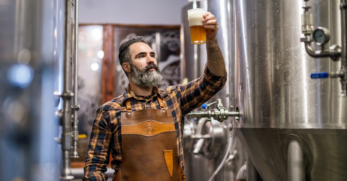 brewery master holding glass of beer