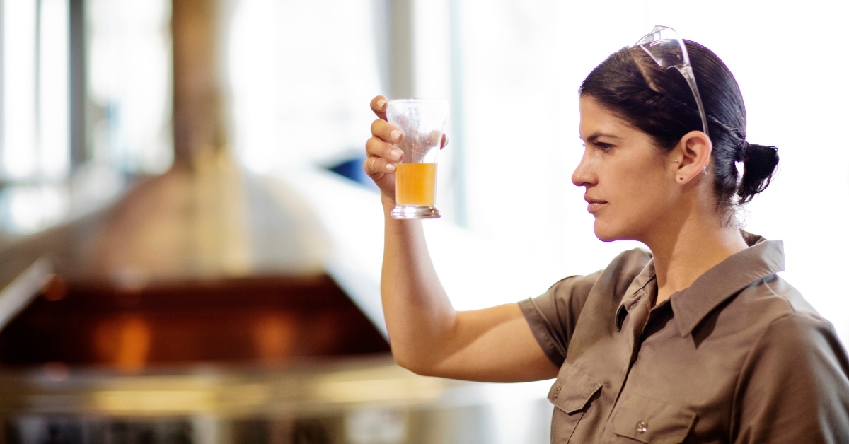 brewery worker holding glass of beer