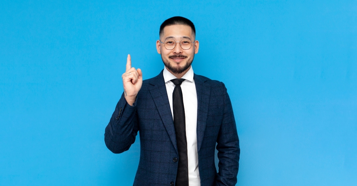 asian businessman in suit thumbs up
