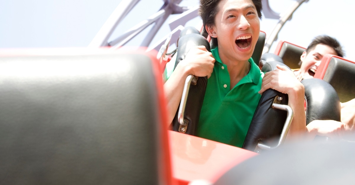 asian man enjoying roller coaster ride