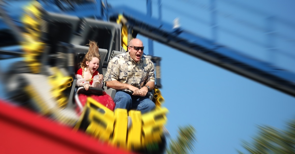 father riding roller coaster with daughter