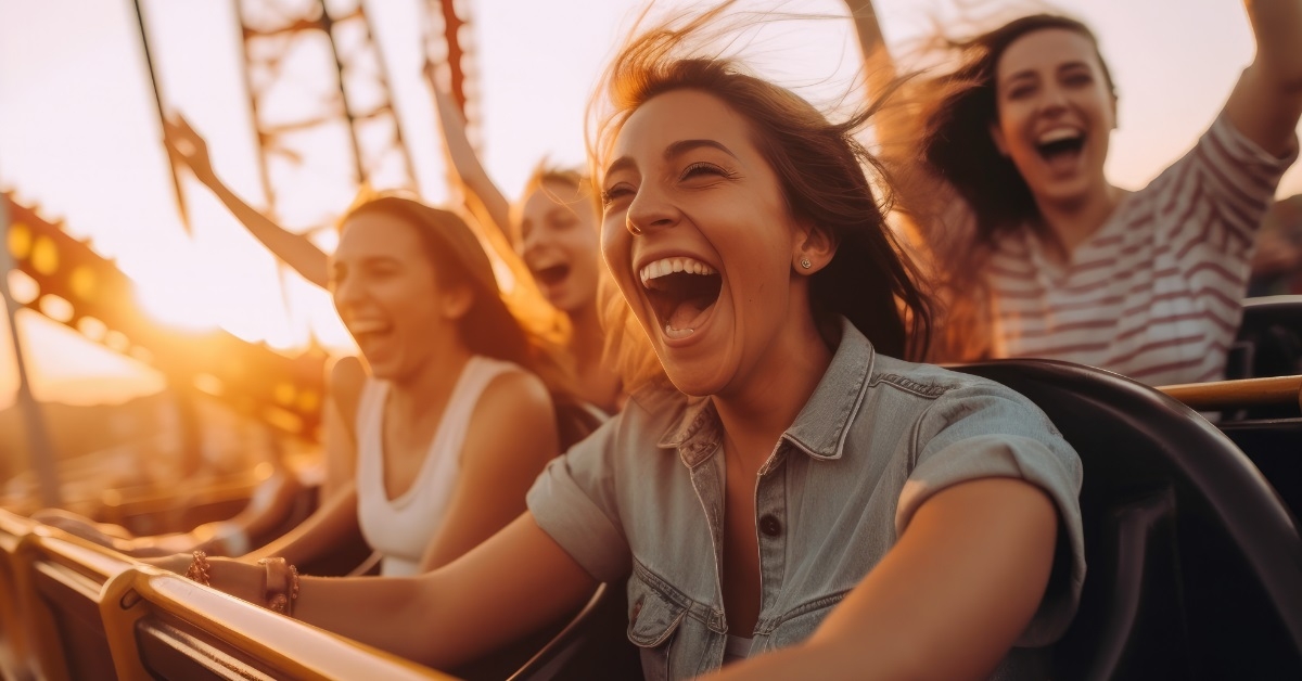 happy female friends riding roller coaster