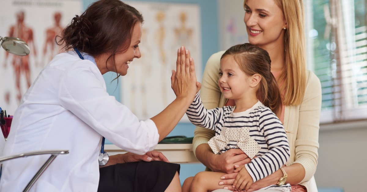 Little girl giving a high five to pediatrician.