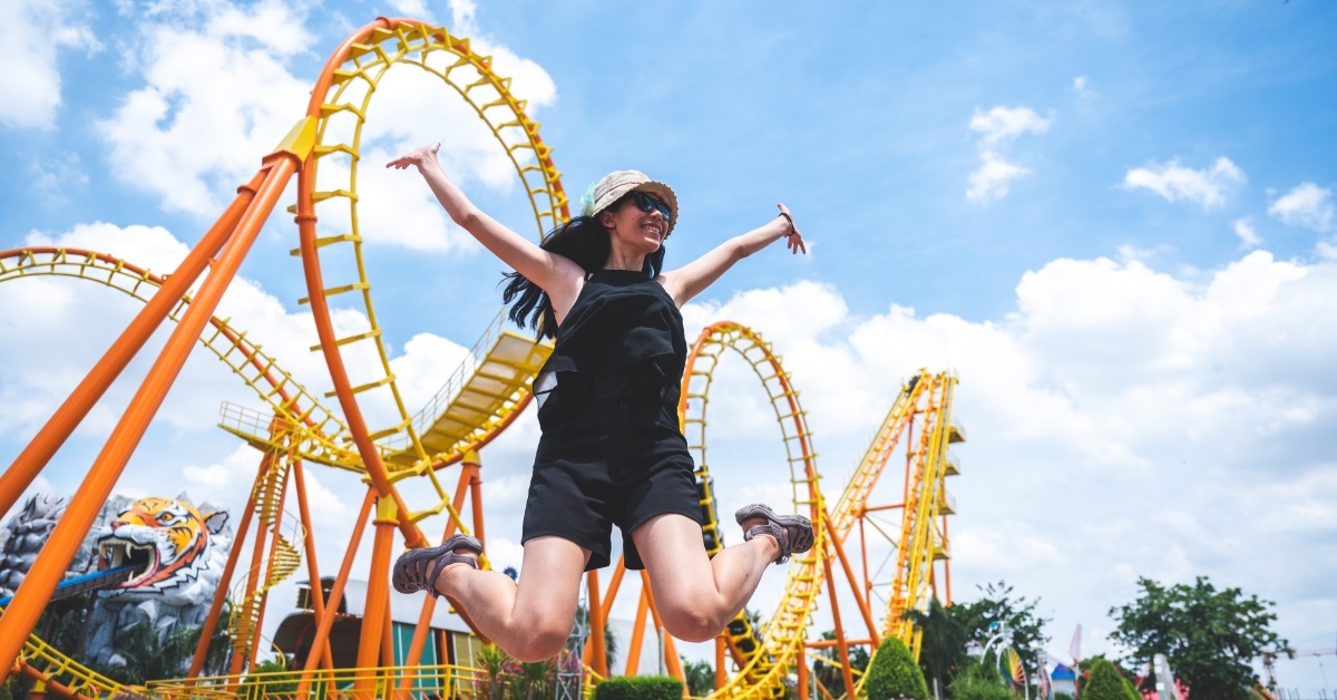 cheerful girl jumping at amusement park