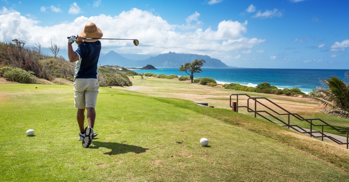 golfer playing golf besides ocean
